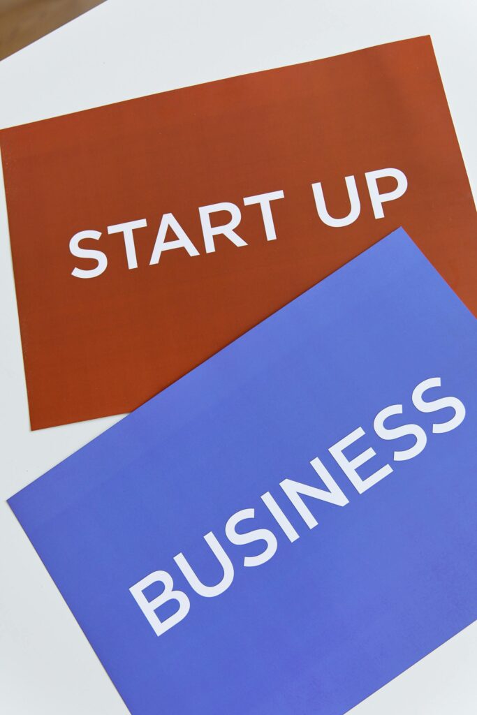 Two colorful placards with 'START UP' and 'BUSINESS' to symbolize modern entrepreneurship.